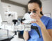 Close up of female dentist looking through dental microscope